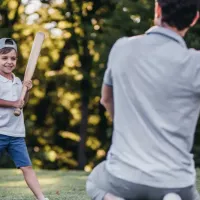 child and adult playing baseball