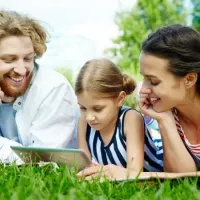 family laying on grass