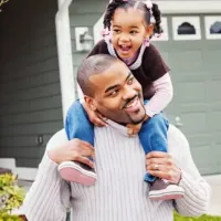 man with child sitting on shoulders