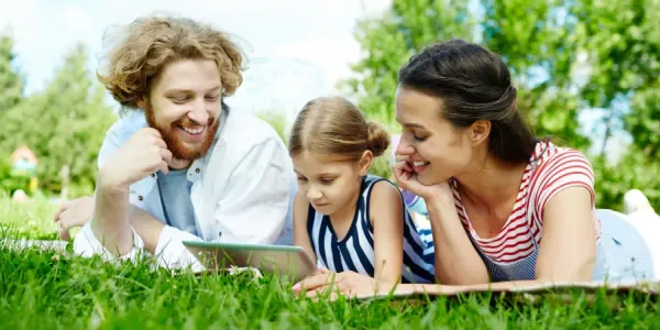 family laying on grass
