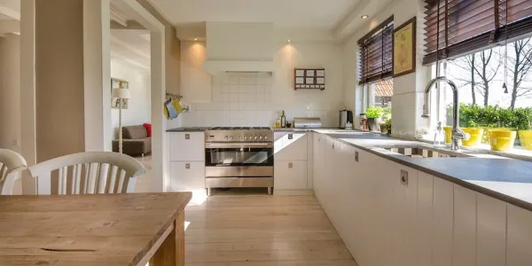 A kitchen with a table and white cabinets