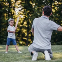 Dad and son playing baseball outside