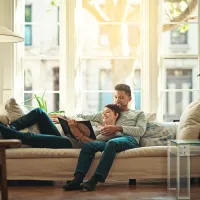 couple lounging on couch and reading a book 