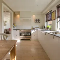 A kitchen with a table and white cabinets