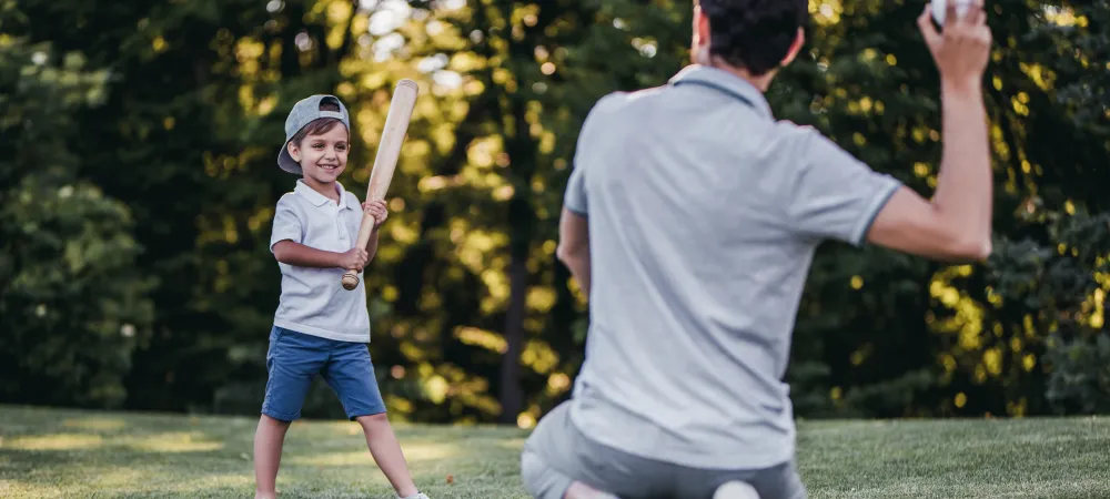 Dad and son playing baseball outside