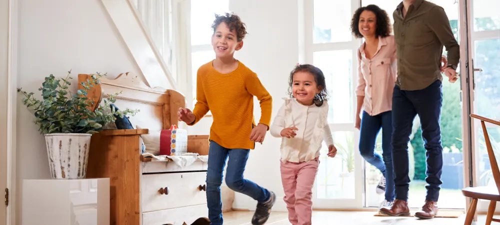 family coming in the front door of the house