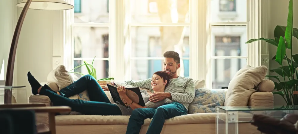 couple lounging on couch and reading a book 