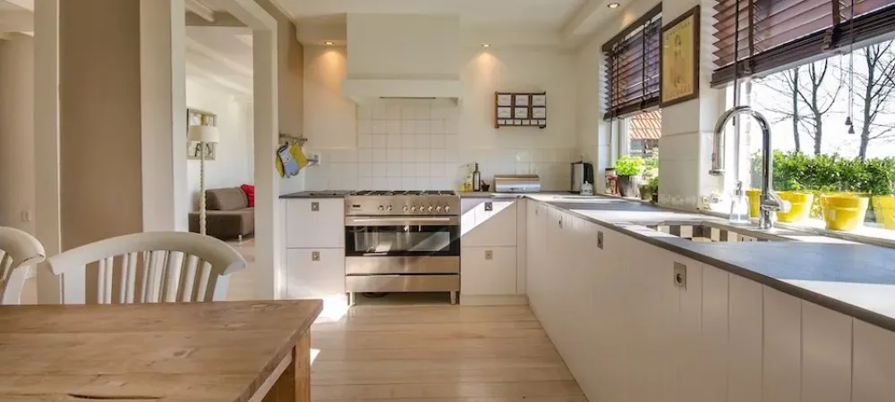 A kitchen with a table and white cabinets