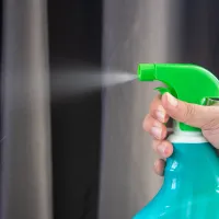 person spraying disinfectant spray