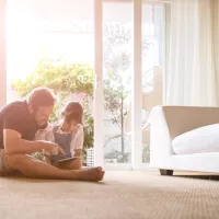 father and daughter looking at tablet 